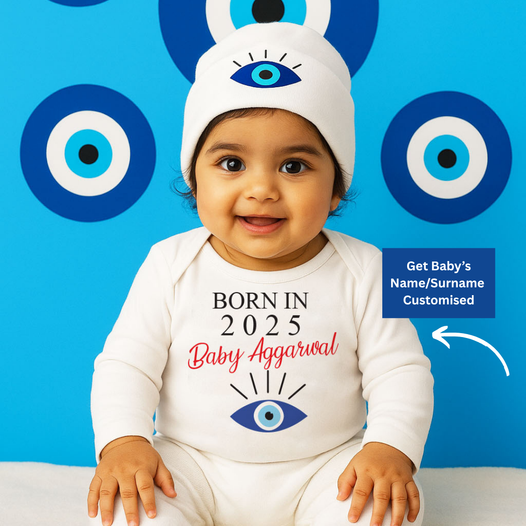 Baby wearing a onesie and hat with eye designs and text, sitting on a blue background with similar eye patterns.