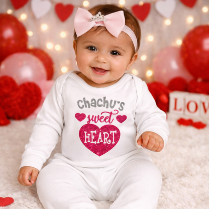 Baby in a 'chachu's sweet heart' onesie surrounded by Valentine's Day decorations.