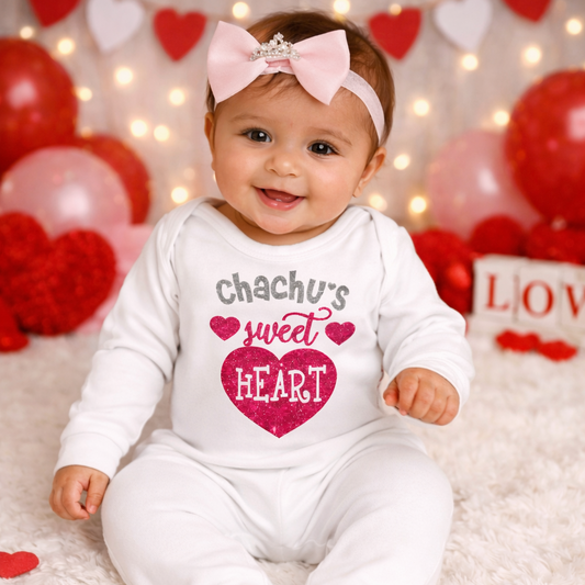 Baby in a 'chachu's sweet heart' onesie surrounded by Valentine's Day decorations.