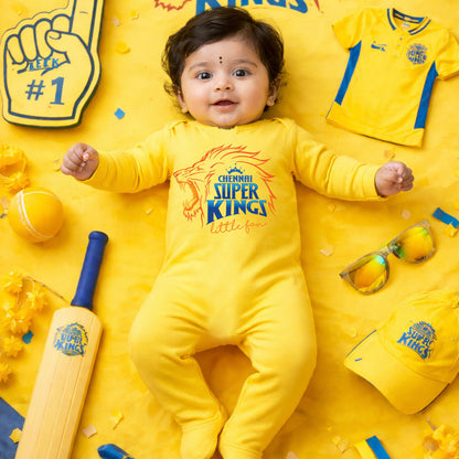 Baby in a yellow outfit with Chennai Super Kings branding surrounded by sports-themed items on a yellow background