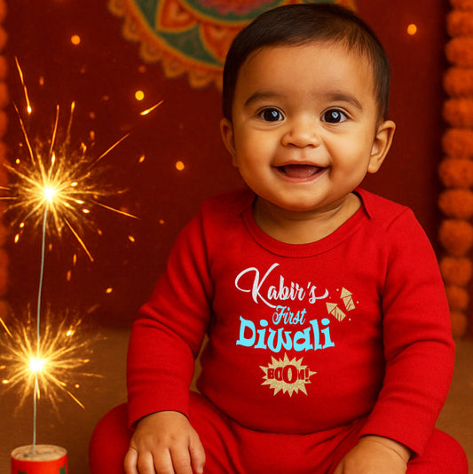 Baby in a red 'First Diwali' onesie with sparklers on a festive background