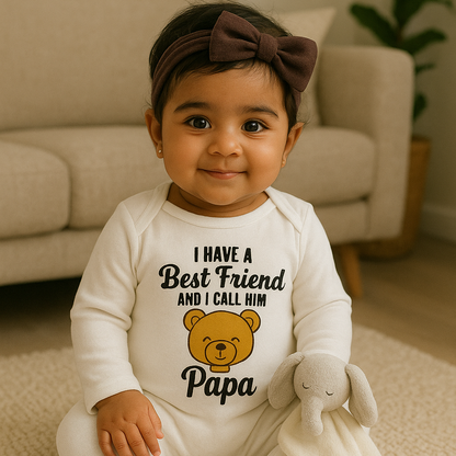 Child wearing a white onesie with text and a teddy bear graphic, sitting on a carpeted floor.